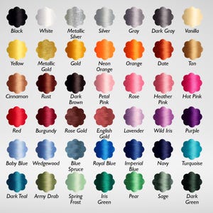May include: A color chart featuring a variety of thread colors. The chart displays a range of hues, including black, white, metallic silver, and various shades of yellow, orange, pink, red, blue, green, and purple. Each color is labeled with its name.