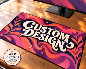 May include: A rectangular desk mat featuring a vibrant, swirling pattern of orange, pink, and purple waves with leaf-like accents. The text CUSTOM DESIGN is printed in large, cream-colored letters. A circular inset shows the text YOUR PHOTO OR DESIGN.