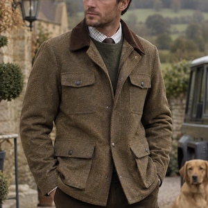 Può includere: Una giacca da campo in tweed marrone con colletto in velluto a coste marrone scuro, dotata di quattro tasche frontali con patta e chiusura a bottone, indossata sopra un maglione verde oliva e una camicia a quadri bianchi e marroni con cravatta.