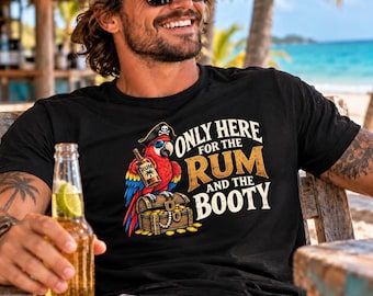 Könnte beinhalten: Ein schwarzes T-Shirt mit einer Grafik eines bunten Papageis, der einen Piratenhut und eine Sonnenbrille trägt, eine Flasche Rum hält und auf einer mit Goldmünzen gefüllten Schatztruhe sitzt, mit dem Text ONLY HERE FOR THE RUM AND THE BOOTY.