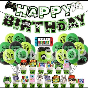 Op de afbeelding: Een feestelijke verjaardagsdecoratieset met een gamingthema. Bevat een banner met de tekst "Happy Birthday", ballonnen, cupcakes en een taart. Het kleurenschema is groen, zwart en wit. De set bevat een taart met een "X".