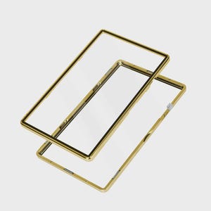 May include: Two clear phone cases with gold-colored frames. The cases are rectangular with rounded corners and a black border around the clear screen area. One case is slightly offset from the other.