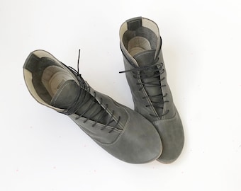 May include: A pair of gray leather lace-up ankle boots with black laces.