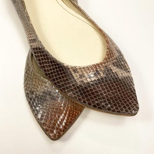 Peut inclure: Une paire de ballerines &agrave; bout pointu avec un motif peau de serpent dans les tons marron, beige et gris. Les chaussures ont un petit talon et une semelle int&eacute;rieure en cuir. Les ballerines sont con&ccedil;ues pour un ajustement confortable et un look &eacute;l&eacute;gant.