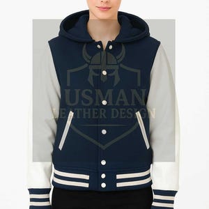 Könnte beinhalten: Marineblaue und weiße Collegejacke mit Kapuze. Die Jacke hat weiße Ärmel, einen marineblauen Körper und weiße Streifen an den Bündchen und am Saum. Der Text "USMAN LEATHER DESIGN" ist sichtbar.