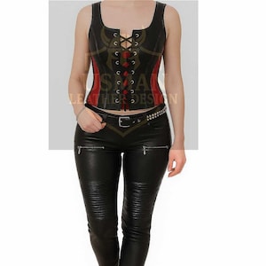 Könnte beinhalten: Schwarzes Lederkorsett mit roten Akzenten und Schnürdetails. Das Korsett wird mit einer schwarzen Lederhose kombiniert. Der Text "USMA LEATHER DESIGN" ist auf dem Korsett zu sehen.