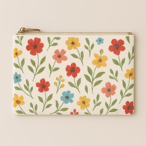 May include: A rectangular cream-colored pouch with a floral pattern. The design features red, yellow, pink, and blue flowers with green stems and leaves. A gold-colored zipper and pull complete the design.