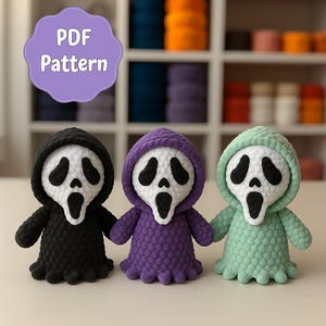 May include: Three handmade crochet dolls in black, purple, and mint green, each with a white face and black eye details, resembling the Ghostface mask. The dolls have hooded tops and small arms. A purple label with "PDF Pattern" is in the background.