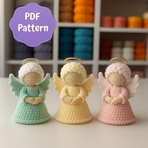 May include: Three handmade crochet angel dolls in pastel colors: mint green, yellow, and pink. Each angel has a halo, wings, and a dress. The image includes a purple sign that says "PDF Pattern".
