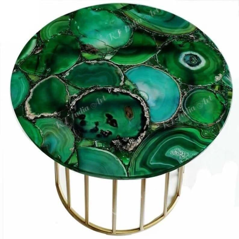 Puede incluir: Una mesa auxiliar redonda con una tapa de piedra de &aacute;gata verde. La piedra es un mosaico de varios tonos de verde y turquesa. La base es un marco de metal color dorado.