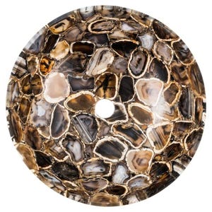 May include: A round, natural stone sink basin. The basin is composed of irregularly shaped, polished agate pieces in shades of brown, gray, and cream, with gold-colored edges. A circular drain hole is centered in the basin.