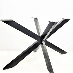 May include: Black metal table base with a starburst design. The base features eight angled legs that converge in the center, with flat mounting plates at the top. The legs are made of thick, solid metal.
