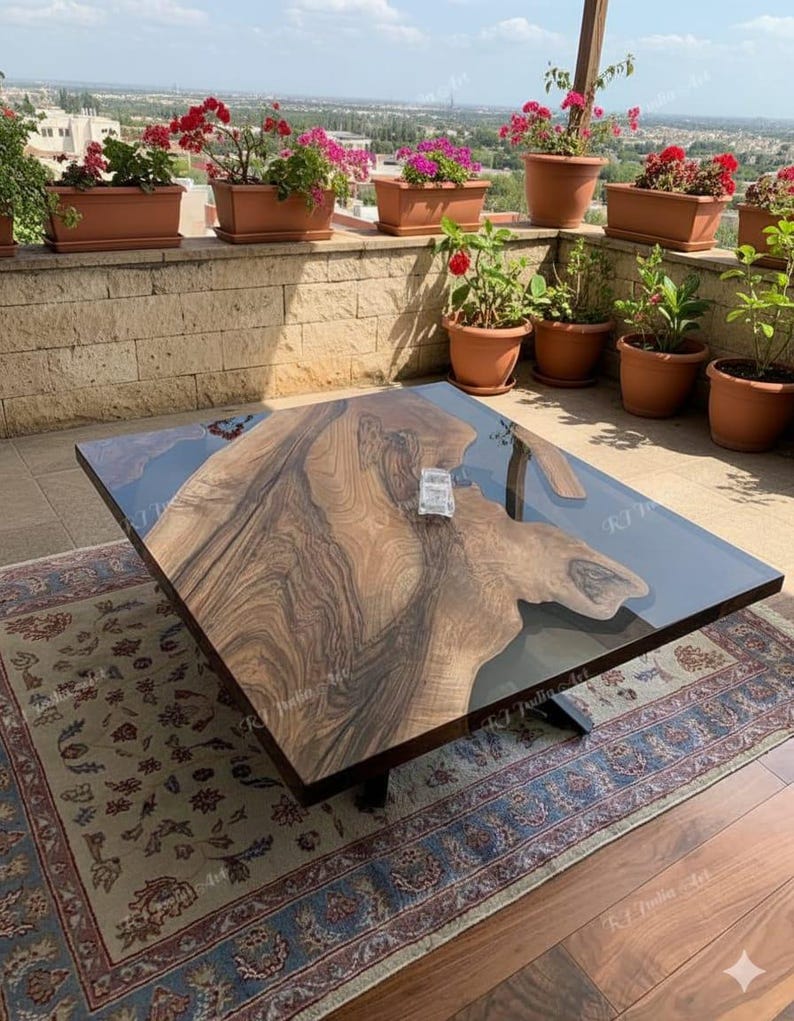 May include: A square wooden coffee table with a dark, glossy finish and a unique wood grain pattern. The table has a clear resin inlay and sits on a black metal base. The table is placed on a patterned rug.