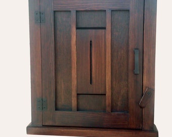 May include: A dark brown wooden cabinet with a single door and a simple design. The door has a rectangular window with a vertical slat.