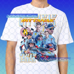 May include: White t-shirt featuring a graphic of a rally car and several people, with the name "Ott Tänak" in gold lettering. The design includes the number "8" in a wreath and the number "1".