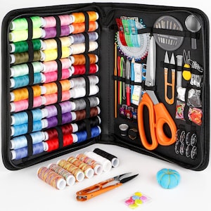 May include: A black sewing kit, open to display a variety of sewing supplies. The kit includes spools of colorful thread, scissors, needles, pins, measuring tape, and other accessories. A small blue pincushion and a pack of colorful buttons are also visible.