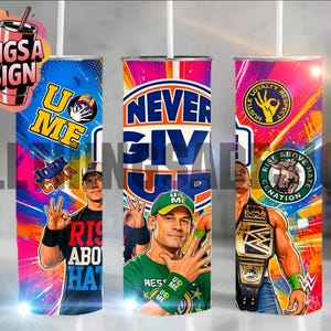 May include: A cylindrical tumbler featuring a vibrant, multi-colored graphic design centered on professional wrestler John Cena. The artwork includes the text "NEVER GIVE UP," "U ME," and "RISE ABOVE HATE," alongside images of the wrestler, a championship belt, and various logos.
