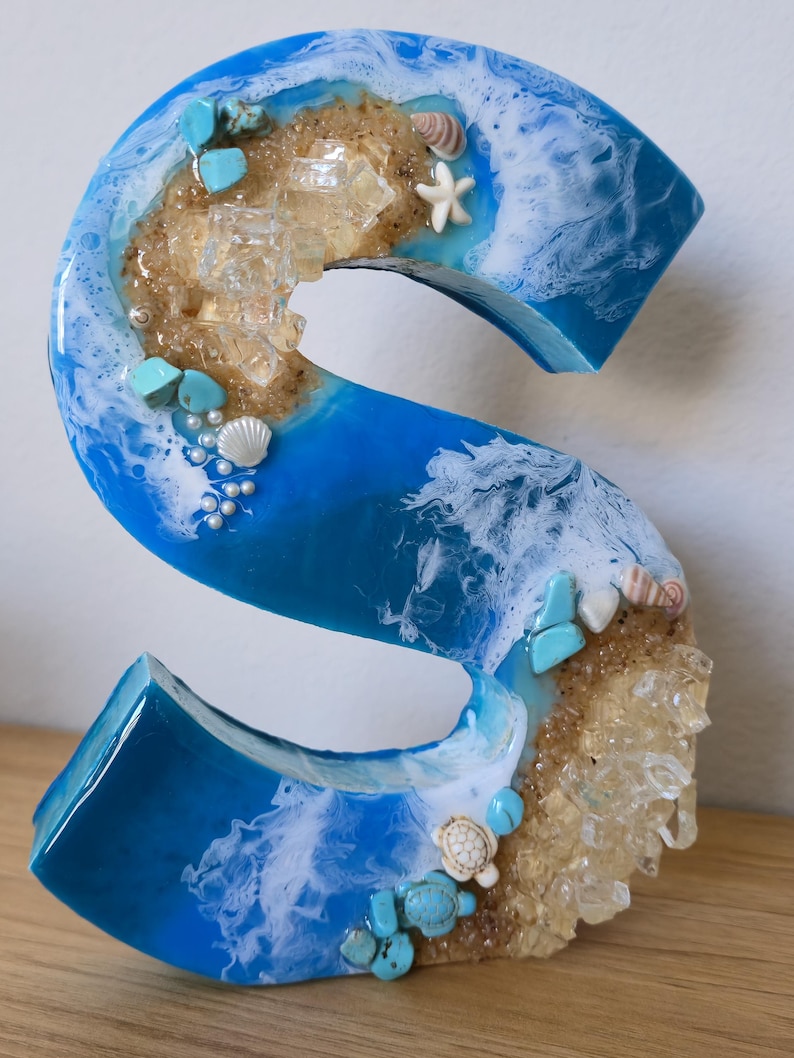 Wolnostojące litery z żywicy oceanicznej z piaskiem kwarcowym w kolorze złotym i muszlami S