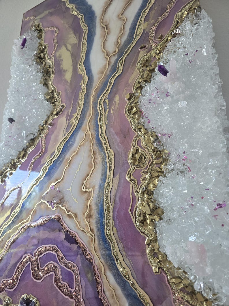 Może przedstawiać: Abstrakcyjne dzieło sztuki z motywem geody w odcieniach fioletu, złota, bieli i błękitu. Obraz ma teksturowaną powierzchnię z kryształowymi akcentami na krawędziach, tworząc unikalną dekorację ścienną.