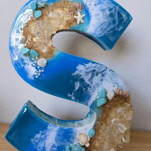 Wolnostojące litery z żywicy oceanicznej z piaskiem kwarcowym w kolorze złotym i muszlami zdjęcie 13