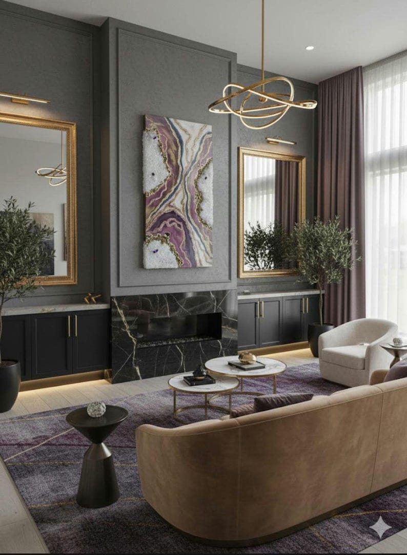 Może przedstawiać: Nowoczesny salon z szarą kolorystyką. Pok&oacute;j posiada brązową sofę, wzorzysty dywan i kominek z czarną marmurową obudową. Lustra w złotych ramach i dekoracyjne oświetlenie dodają elegancji.