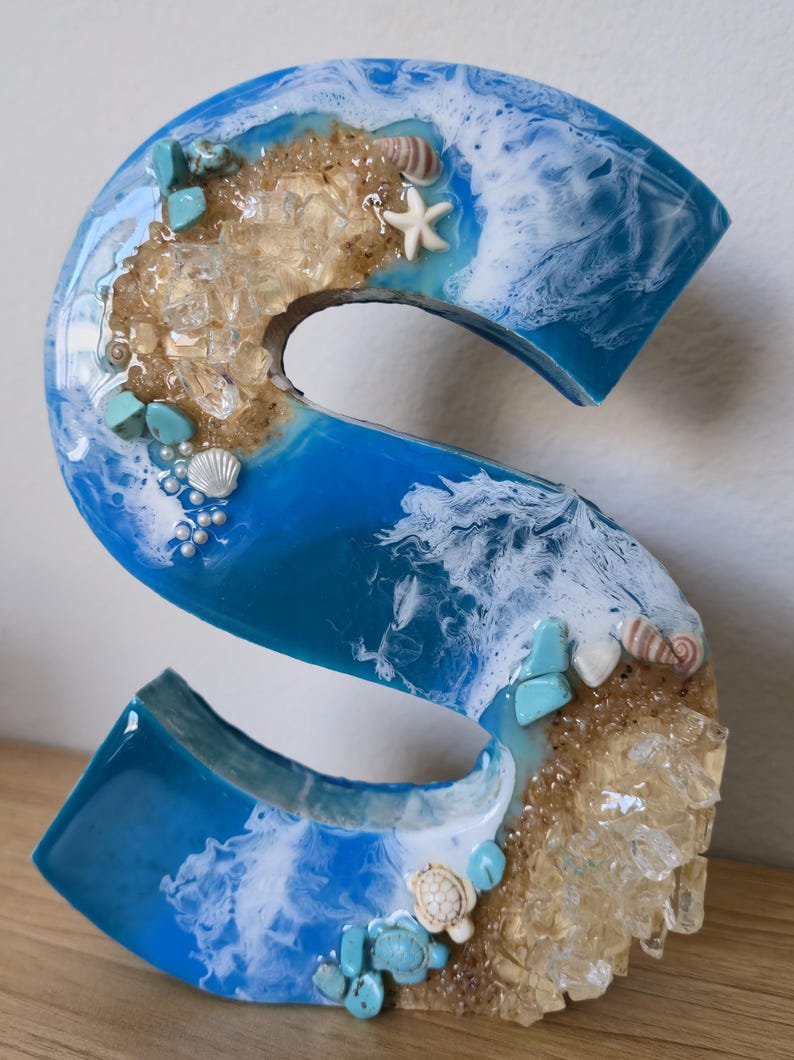Wolnostojące litery z żywicy oceanicznej z piaskiem kwarcowym w kolorze złotym i muszlami zdjęcie 1