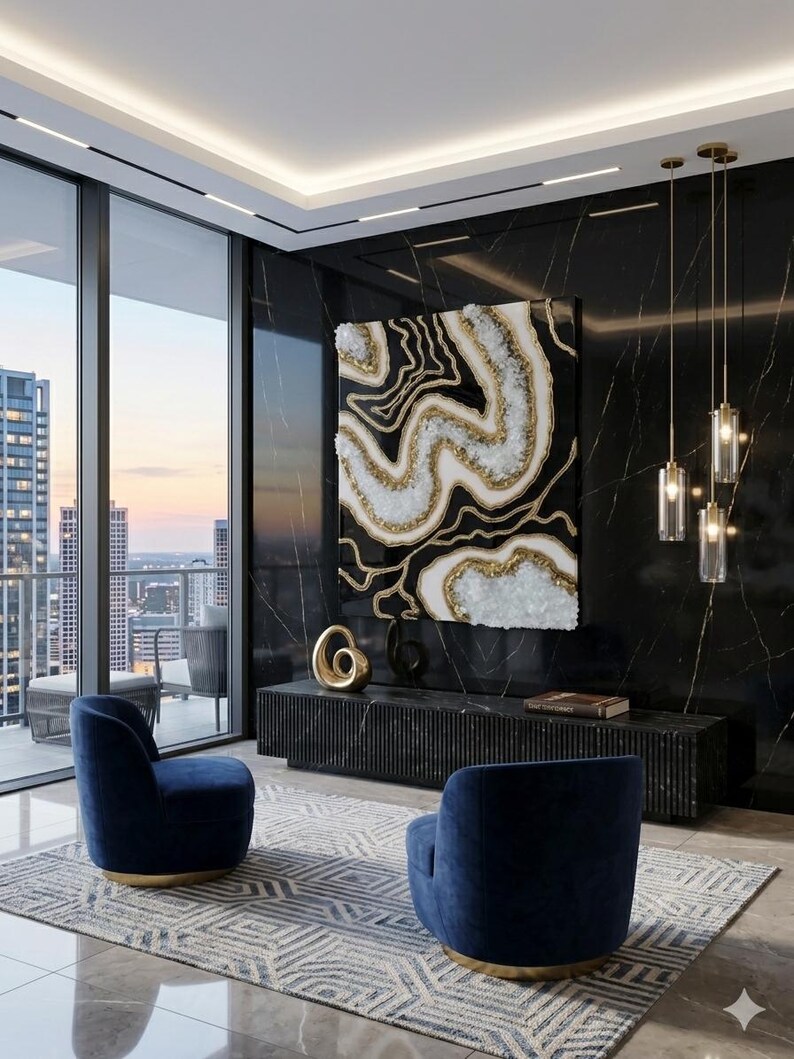 May include: An interior design featuring a large abstract art piece with gold and white accents against a black background. Two navy blue armchairs sit on a patterned rug. The room has large windows and pendant lights.