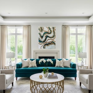 May include: A living room with a teal sofa, two armchairs, and a marble-topped coffee table. A large abstract painting with teal, gold, and white accents hangs above the fireplace. The room has neutral-colored curtains and a patterned rug.