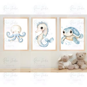 May include: Three framed watercolor prints featuring sea creatures. The prints depict an octopus, a seahorse, and a turtle, all in soft blue and beige tones. The frames are light wood. The overall theme is nautical and suitable for a nursery.