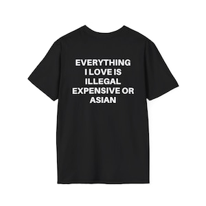 May include: Black t-shirt with the white text "EVERYTHING I LOVE IS ILLEGAL EXPENSIVE OR ASIAN". The shirt has short sleeves and a crew neck. The text is centered on the front of the shirt.