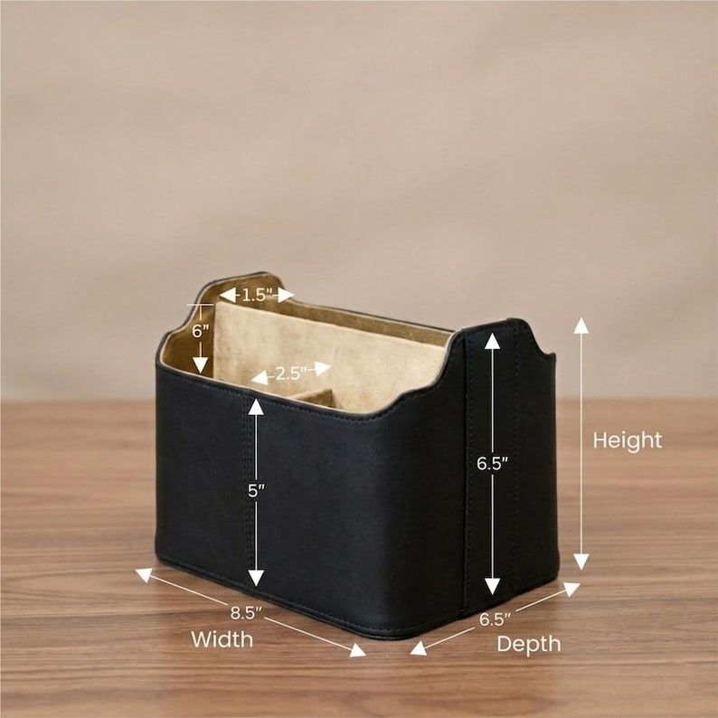 May include: A black leather desk organizer with a beige interior. The organizer is 8.5 inches wide, 6.5 inches deep, and 6.5 inches tall. It has multiple compartments and is designed to hold office supplies.