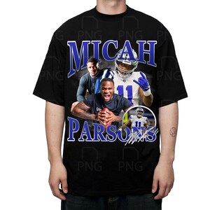 May include: Black t-shirt featuring a graphic of Micah Parsons, a football player, in a vintage style. The design includes the name "Micah Parsons" in blue and white, along with images of the player in action. The shirt is worn by a person.