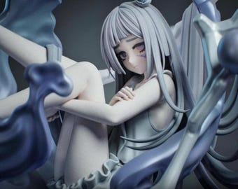 May include: A detailed figurine of a seated anime-style character with long, flowing silver hair and a serene expression. The figure is dressed in a light-colored outfit and is surrounded by abstract, flowing blue and white forms. The figurine has a small headpiece.