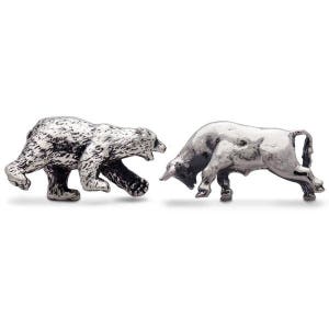 May include: A pair of metallic silver-toned figurines featuring a bear and a bull. The bear is depicted in a walking stance with textured fur details, while the bull is shown in a charging position with a smooth, polished finish and curved horns.