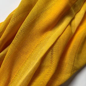 May include: A white ceramic mug with a black handle and the text "But First, Coffee" in a handwritten style. The mug is on a white surface. The mug is approximately 10 cm tall.