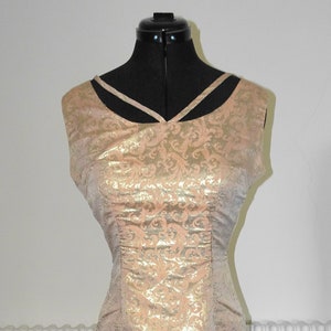 May include: A sleeveless gold and pink dress with a floral pattern. The dress has a fitted bodice and a straight skirt.