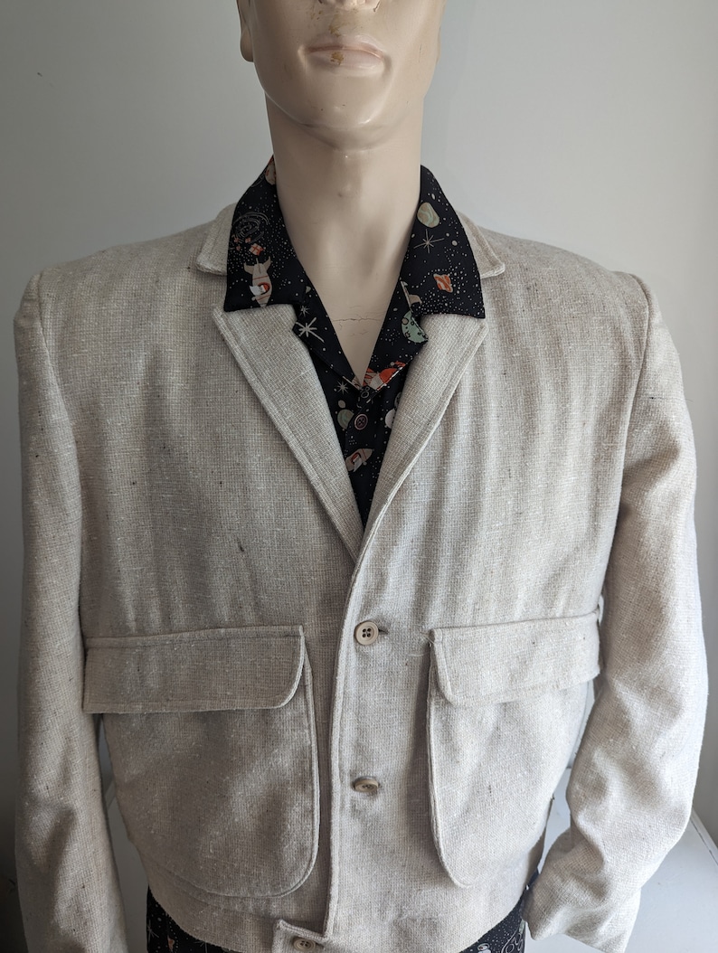 May include: A light beige linen blazer with two large patch pockets and a button closure. The blazer has a slightly cropped length and a relaxed fit.