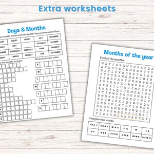 May include: Two white worksheets with blue headings and text. One worksheet is titled "Days & Months" and the other is titled "Months of the year". The worksheets are on a light wood-grain surface.