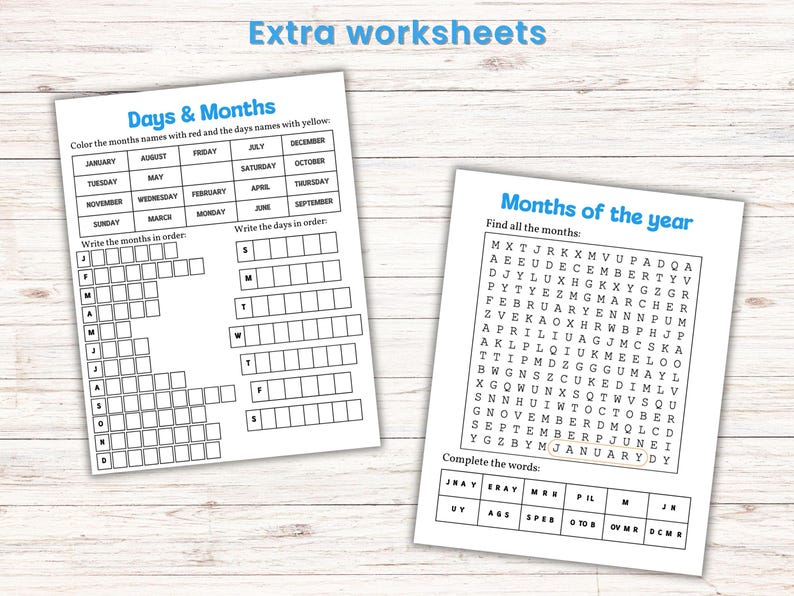 May include: Two white worksheets with blue headings and text. One worksheet is titled "Days & Months" and the other is titled "Months of the year". The worksheets are on a light wood-grain surface.
