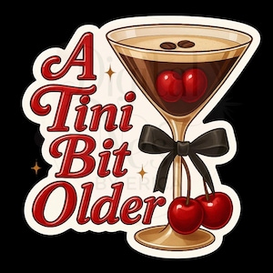 May include: A sticker depicting a cocktail with cherries and coffee beans. The glass has a black bow and the text "A Tini Bit Older" in red script. The background is black.