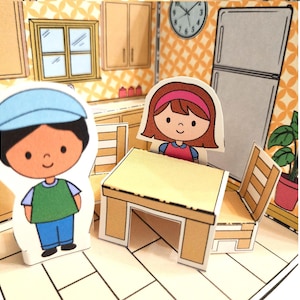 May include: A paper doll kitchen scene with a table, chairs, and two paper dolls. The kitchen has a window, cabinets, and a refrigerator. The dolls are a boy wearing a blue cap and a girl with a pink headband.