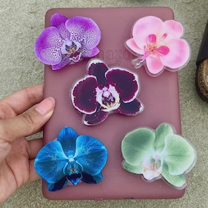 May include: A white ceramic mug with a black handle and the text "But First, Coffee" in a bold, black font. The mug is set against a blurred background, suggesting a cosy setting.