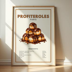 Pode incluir: Uma impressão emoldurada com profiteroles com molho de chocolate. O texto "PROFITEROLES PARIS" está no topo. Abaixo estão os ingredientes: massa choux, creme de leite, açúcar, chocolate amargo, manteiga e leite.