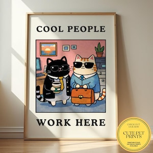 Può includere: Una stampa incorniciata con un'illustrazione di due gatti in abito e occhiali da sole. Un gatto tiene una tazza di caffè, l'altro una valigetta. Il testo in alto dice "COOL PEOPLE", e in basso "WORK HERE". Un adesivo dice "CUTE PET PRINTS".