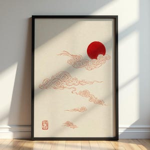 Può includere: Stampa artistica incorniciata con un sole rosso e nuvole rosse stilizzate su sfondo crema. L'opera d'arte ha un'estetica minimalista, con un design di ispirazione giapponese. Un sigillo rosso si trova nell'angolo in basso a sinistra.