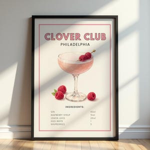 May include: A framed wall art print titled CLOVER CLUB PHILADELPHIA featuring a pink cocktail in a stemmed glass garnished with raspberries. Below the glass, the text lists ingredients: GIN 45ml, RASPBERRY SYRUP 15ml, LEMON JUICE 20ml, EGG WHITE 1, RASPBERRIES 3.