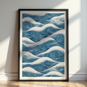Può includere: Stampa incorniciata raffigurante onde oceaniche stilizzate. L'opera presenta un motivo ripetuto di onde blu con creste bianche su sfondo crema. La stampa è racchiusa in una cornice nera, adatta per l'arredamento murale.
