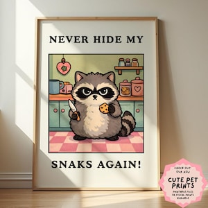 May include: A framed print featuring a cartoon raccoon holding a knife and a cookie in a kitchen setting. The text reads "NEVER HIDE MY SNAKS AGAIN!". The print has a pink and white checkered floor and a pink heart-shaped decoration.