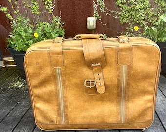 Vintage leather suitcase with tiny wheels at bottom