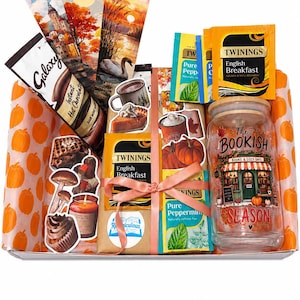 Può includere: Una scatola regalo foderata con carta con stampa di zucche arancioni contenente un bicchiere di vetro con coperchio in bambù etichettato The Bookish Season, bustine di tè Twinings, una bustina di cioccolata calda Galaxy e tre segnalibri autunnali.
